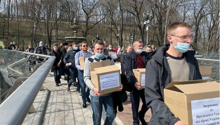 Віруючі УПЦ несуть коробки з підписами під зверненням до Зеленського. Фото: СПЖ