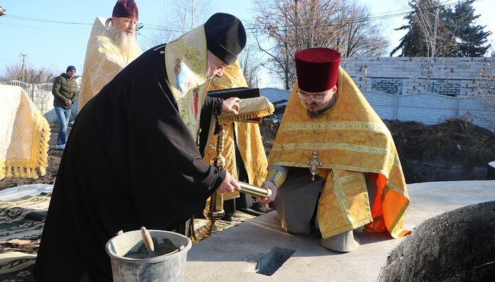 Митрополит Іриней з настоятелем звершують закладку мощей у фундамент храму в Новоолександрівці. Фото: eparhia.dp.ua