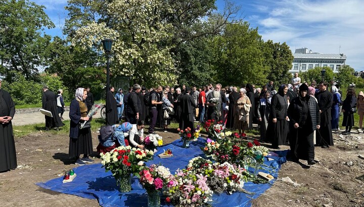 Kyiv citizens and clergy bring flowers to the destroyed Tithe Church