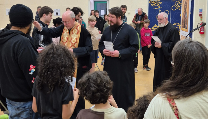 A priest from the Manchester parish blesses adults and children for catechism classes at a school in Halifax. Photo: antiochian-orthodox